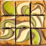 Pistachio Cheesecake Blondies topped with crushed pistachios and creamy cheesecake swirl