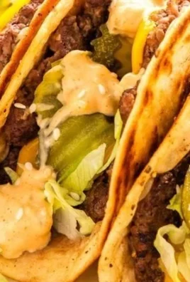 Delicious smash burger tacos served with toppings on a plate