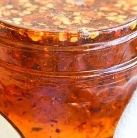 Jar of Vegan Hot Honey with chili peppers and honey drizzled on toast