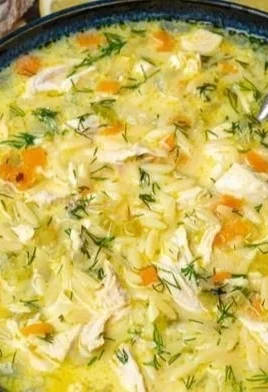Bowl of Avgolemono, Greek lemon chicken soup garnished with fresh herbs