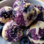 Blueberry cheesecake bites on a decorative plate with fresh blueberries