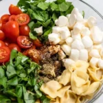 Caprese Salad with Tortellini featuring tomatoes, mozzarella, and basil