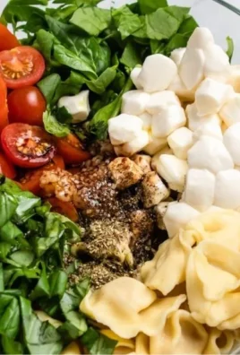 Caprese Salad with Tortellini featuring tomatoes, mozzarella, and basil
