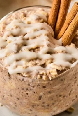 Bowl of cinnamon roll overnight oats topped with cinnamon and nuts