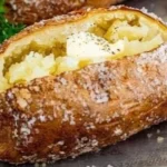 Crispy baked potatoes with golden skin and fluffy interior served on a plate