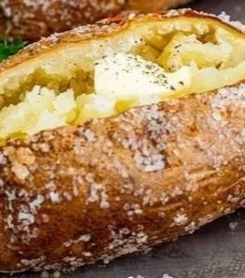 Crispy baked potatoes with golden skin and fluffy interior served on a plate