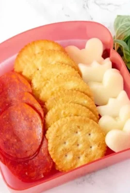 DIY Pizza Crackers Lunchable with cheese, pepperoni, and dipping sauce.