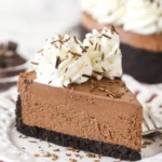 No bake chocolate cheesecake topped with chocolate shavings on a white plate