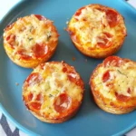 Homemade pizza muffins for toddlers and kids, topped with cheese and pepperoni.