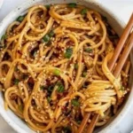 Delicious Garlic Sesame Noodles garnished with sesame seeds and green onions