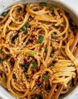 Delicious Garlic Sesame Noodles garnished with sesame seeds and green onions