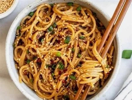 Delicious Garlic Sesame Noodles garnished with sesame seeds and green onions