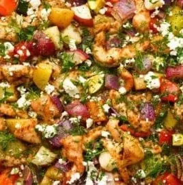 Delicious Greek sheet pan chicken and veggies on a baking tray.