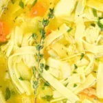 Bowl of Healing Chicken Noodle Soup with fresh vegetables and noodles