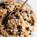 Bowl of healthy edible protein cookie dough with chocolate chips and nuts