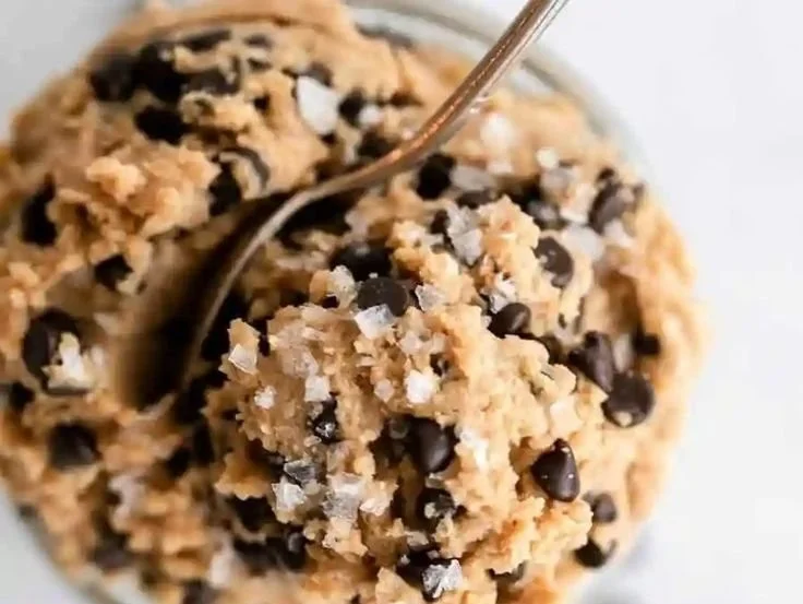 Bowl of healthy edible protein cookie dough with chocolate chips and nuts