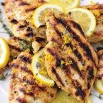 Lemon marinade drizzled over marinated chicken ready for grilling.