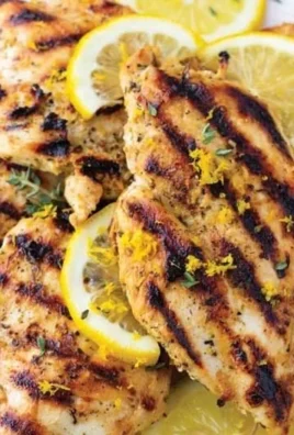 Lemon marinade drizzled over marinated chicken ready for grilling.