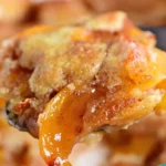 A golden-brown peach cobbler baked to perfection, topped with fresh peaches.
