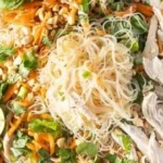 Bowl of Rice Noodle Salad with Chicken, colorful vegetables, and dressing