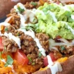 Delicious taco stuffed sweet potatoes topped with fresh ingredients and garnishes.